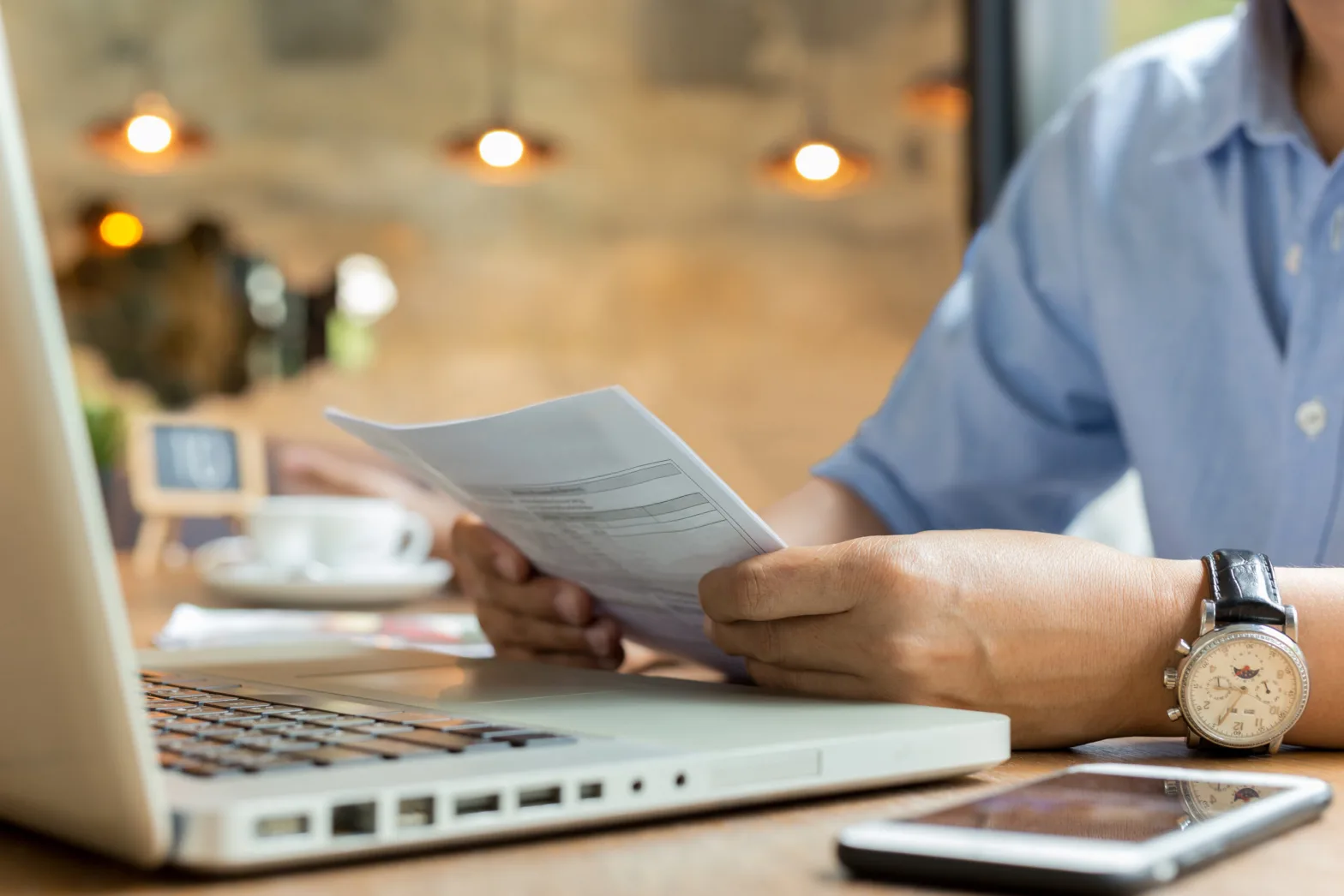 businessman using laptop while looking at invoice