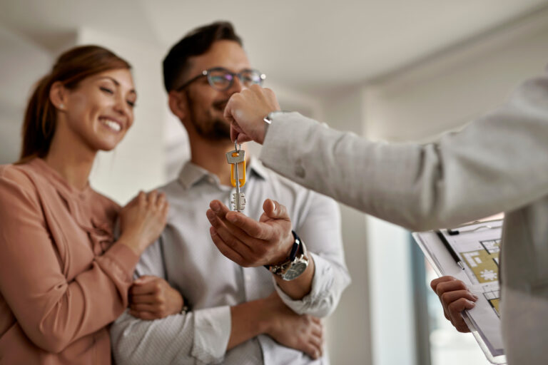 Blog 1 primer plano de un agente de bienes raices dando un par de llaves de su nuevo hogar